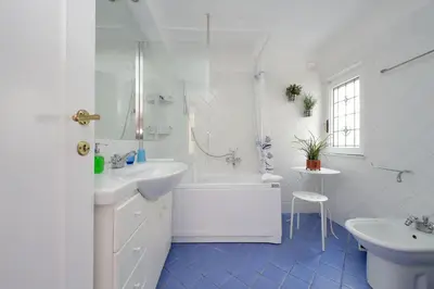 a white bathroom with a tub and a sink and a bath tubermott at 4BNB - Navona Rooftop in Rome