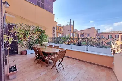 a patio with a table and chairs on a balcony at 4BNB - Navona Rooftop in Rome