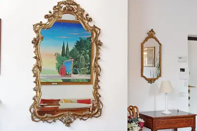 an ornate mirror on a wall next to a table at 4BNB - Navona Rooftop in Rome