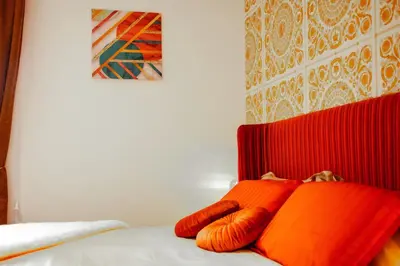 a bed with two orange pillows on top of it at 4 Min From Metro ''A'' Apt 15 Min from Colosseum in Rome