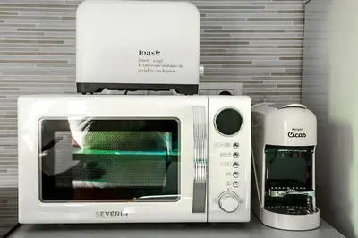 a white microwave next to a coffee maker at 4 Min From Metro ''A'' Apt 15 Min from Colosseum in Rome