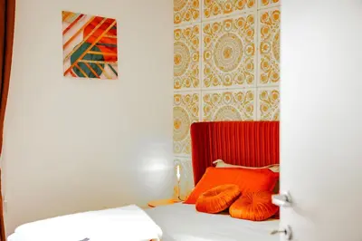 a room with a bed with orange pillows on it at 4 Min From Metro ''A'' Apt 15 Min from Colosseum in Rome
