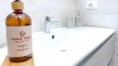 a bottle of wine sitting on a bathroom sink at 4 Min From Metro ''A'' Apt 15 Min from Colosseum in Rome