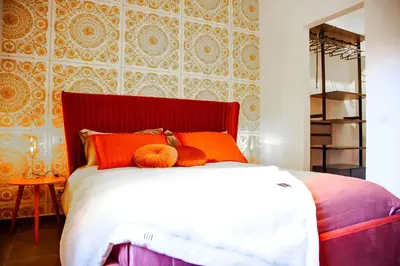 a bedroom with a large bed with orange pillows at 4 Min From Metro ''A'' Apt 15 Min from Colosseum in Rome