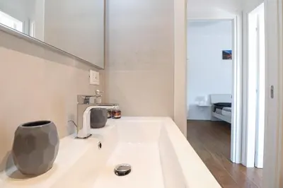 a white bathroom with a sink and a mirror at Apartments Portuense in Rome