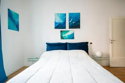 a bedroom with a bed with two paintings on the wall at San Giovanni Art Apartment in Rome
