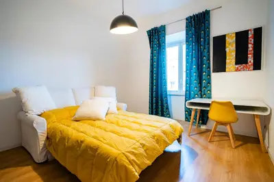 a bedroom with a yellow bed and a desk at San Giovanni Art Apartment in Rome