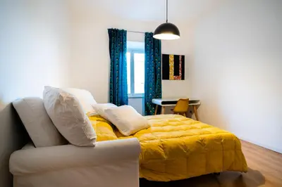 a bedroom with a yellow bed and a white couch at San Giovanni Art Apartment in Rome
