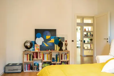 a bedroom with a bed and a book shelf with books at San Giovanni Art Apartment in Rome