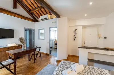 a kitchen and living room with a table and a fireplace at Piazza Navona the most central apartment in Rome