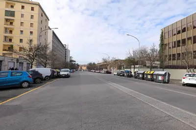 an empty street with parked cars in a city at Casa Cestia San Saba in Rome