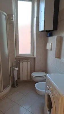 a bathroom with a toilet and a washing machine at Da Fedelisa in Rome