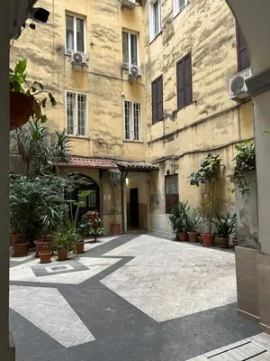 a large building with a courtyard with potted plants at Brina-House, Mini Apartment in Rome