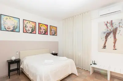 a white bedroom with a bed and some pictures on the wall at Casa vacanze Alle Mura Aureliane in Rome