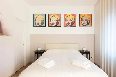 a bedroom with a white bed with four pictures on the wall at Casa vacanze Alle Mura Aureliane in Rome