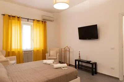 a bedroom with a bed and a tv on the wall at Casa Vacanze Fausta in Rome