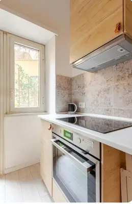 a small kitchen with a stove and a window at Casa d' artista Margot in Rome