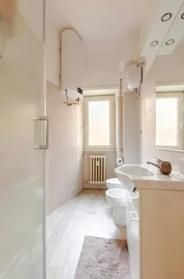 a white bathroom with two toilets and a sink at Casa d' artista Margot in Rome