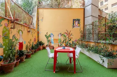 a patio with a red table and chairs and plants at Casa d' artista Margot in Rome