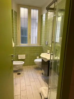 a green bathroom with two toilets and a sink at GA Holidays Home2 in Rome