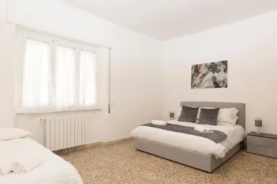 a white bedroom with a bed and a window at Central Modern Apartment - Trastevere & Vaticano in Rome