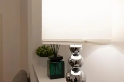 a table with a lamp and a white window at Central Modern Apartment - Trastevere & Vaticano in Rome