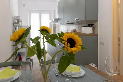 a vase of sunflowers sitting on a table in a kitchen at Central Modern Apartment - Trastevere & Vaticano in Rome