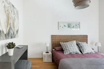 a white bedroom with a bed and a desk at Charming apartment near Villa Borghese in Rome