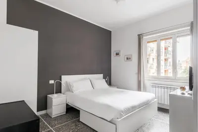 a bedroom with a white bed and a window at Porta Furba Apartment in Rome
