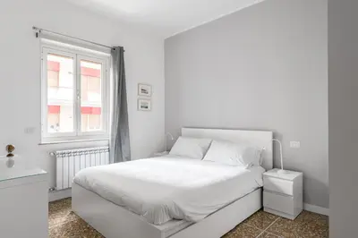 a white bedroom with a white bed and a window at Porta Furba Apartment in Rome