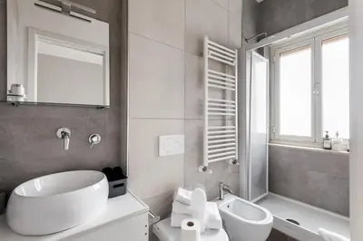 a bathroom with a sink and a tub and a mirror at Porta Furba Apartment in Rome