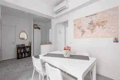 a white dining room with a white table and chairs at Porta Furba Apartment in Rome