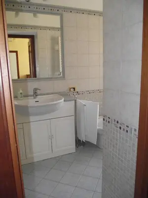 a bathroom with a tile floor and a door at Casa Kathy Rome in Rome