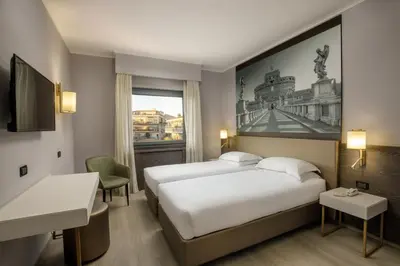 a hotel room with two beds and a window at Hotel Marc'Aurelio in Rome
