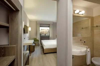 a bathroom with a sink and a bed and a mirror at Hotel Marc'Aurelio in Rome
