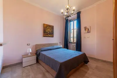 a bedroom with a bed and a chandelier at GuestHost - Sweety Apartment near MM Ottaviano in Rome