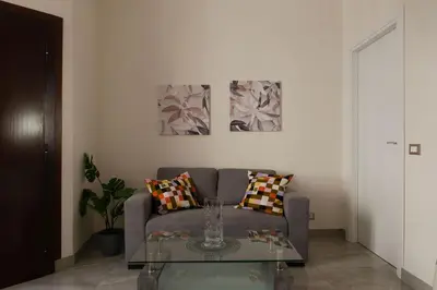 a living room with a couch and a glass table at GuestHost - Sweety Apartment near MM Ottaviano in Rome