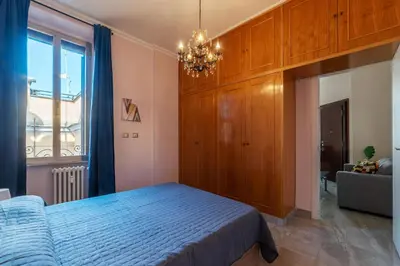 a bedroom with a blue bed and a chandelier at GuestHost - Sweety Apartment near MM Ottaviano in Rome