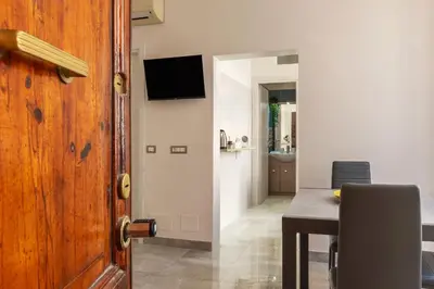 a room with a table and a door with a dining room at GuestHost - Sweety Apartment near MM Ottaviano in Rome