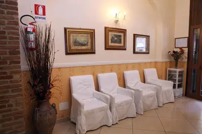 a row of white chairs in a waiting room at Hotel Hollywood in Rome
