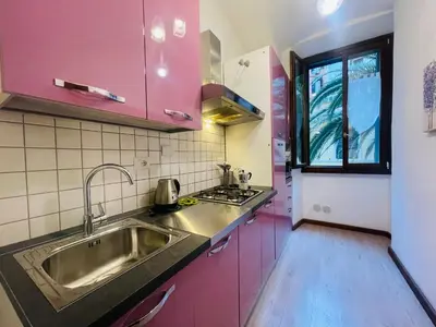 a kitchen with pink cabinets and a sink at Colosseum-Apartments in Rome
