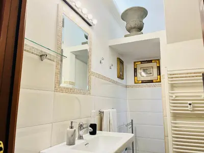 a white bathroom with a sink and a mirror at Colosseum-Apartments in Rome