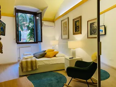a bedroom with a bed and a chair and a window at Colosseum-Apartments in Rome