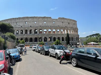 a row of parked cars in front of the coliseum at Colosseum-Apartments in Rome