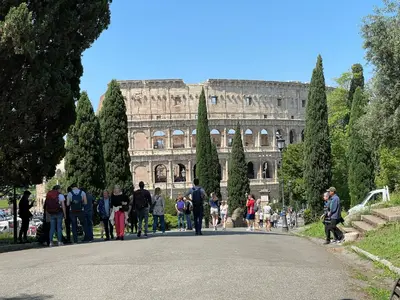 a group of people walking down a road in front of a building at Colosseum-Apartments in Rome