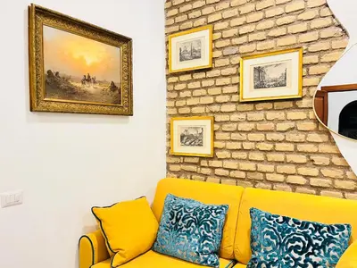 a living room with a yellow couch and a brick wall at Colosseum-Apartments in Rome