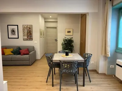 a dining room with a table and chairs and a couch at Suite dell'Arte - Metro linea A in Rome