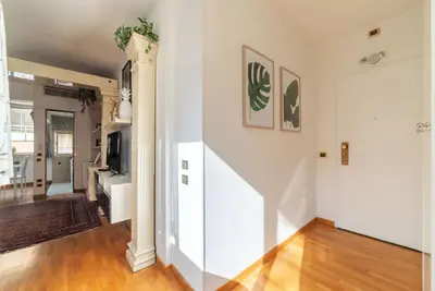 a living room with a white wall and a door at Along the Tiber Apartment in Rome