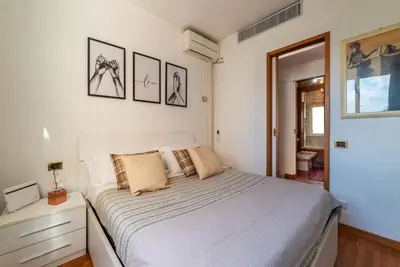 a bedroom with a white bed and some pictures on the wall at Along the Tiber Apartment in Rome