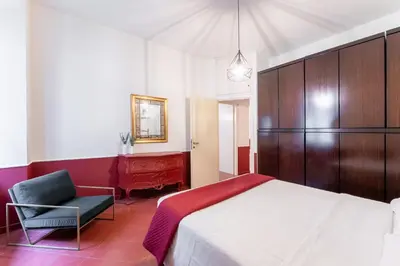 a bedroom with a bed and a chair and a desk at Maroon Flat Colosseo, 800 mt from Amphitheater in Rome